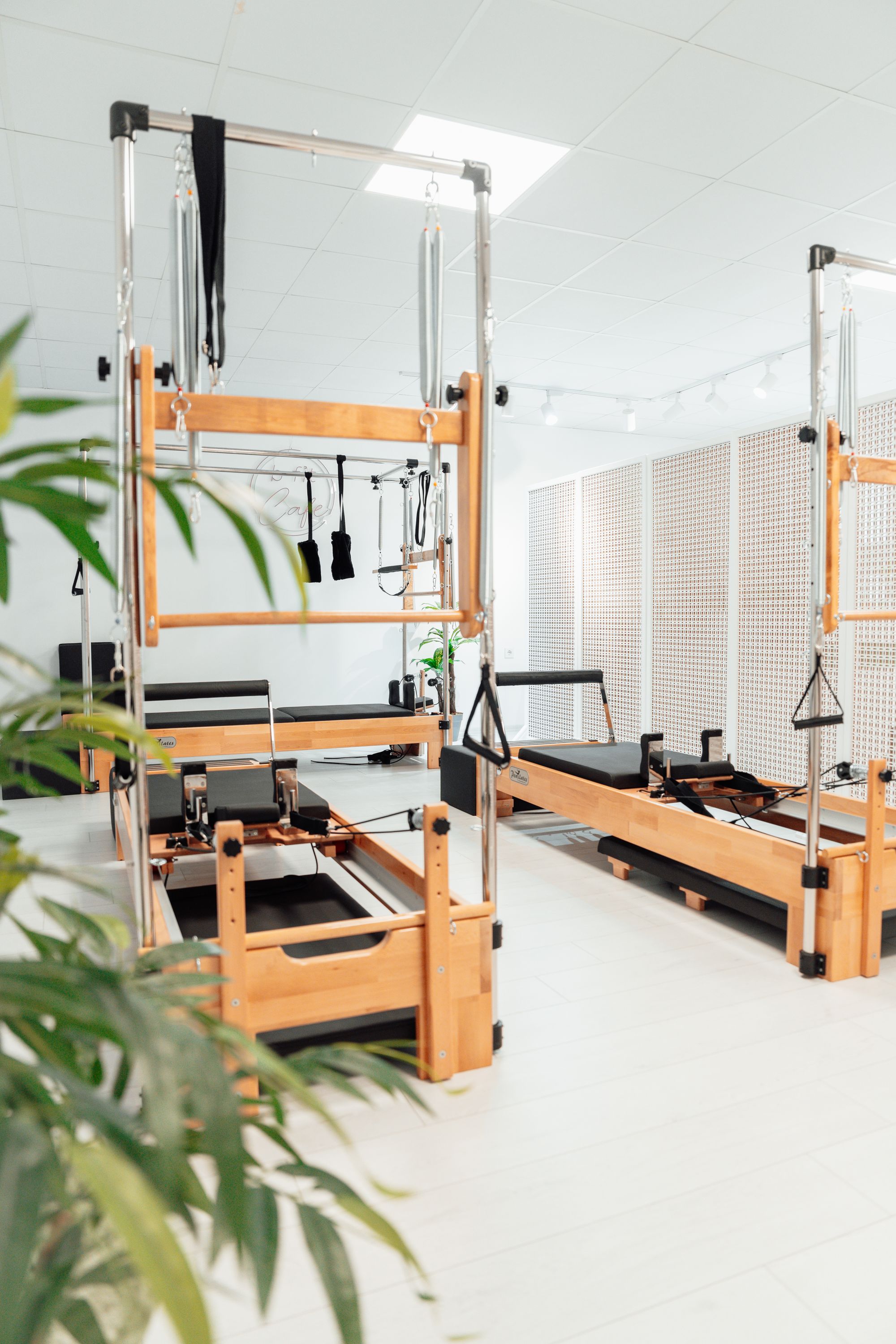 Világos mozgásstúdió pilates-tornyokkal és növényekkel